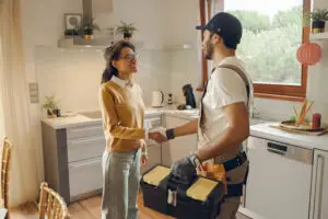 Uniformed service technician shaking hands with a homeowner at the front door