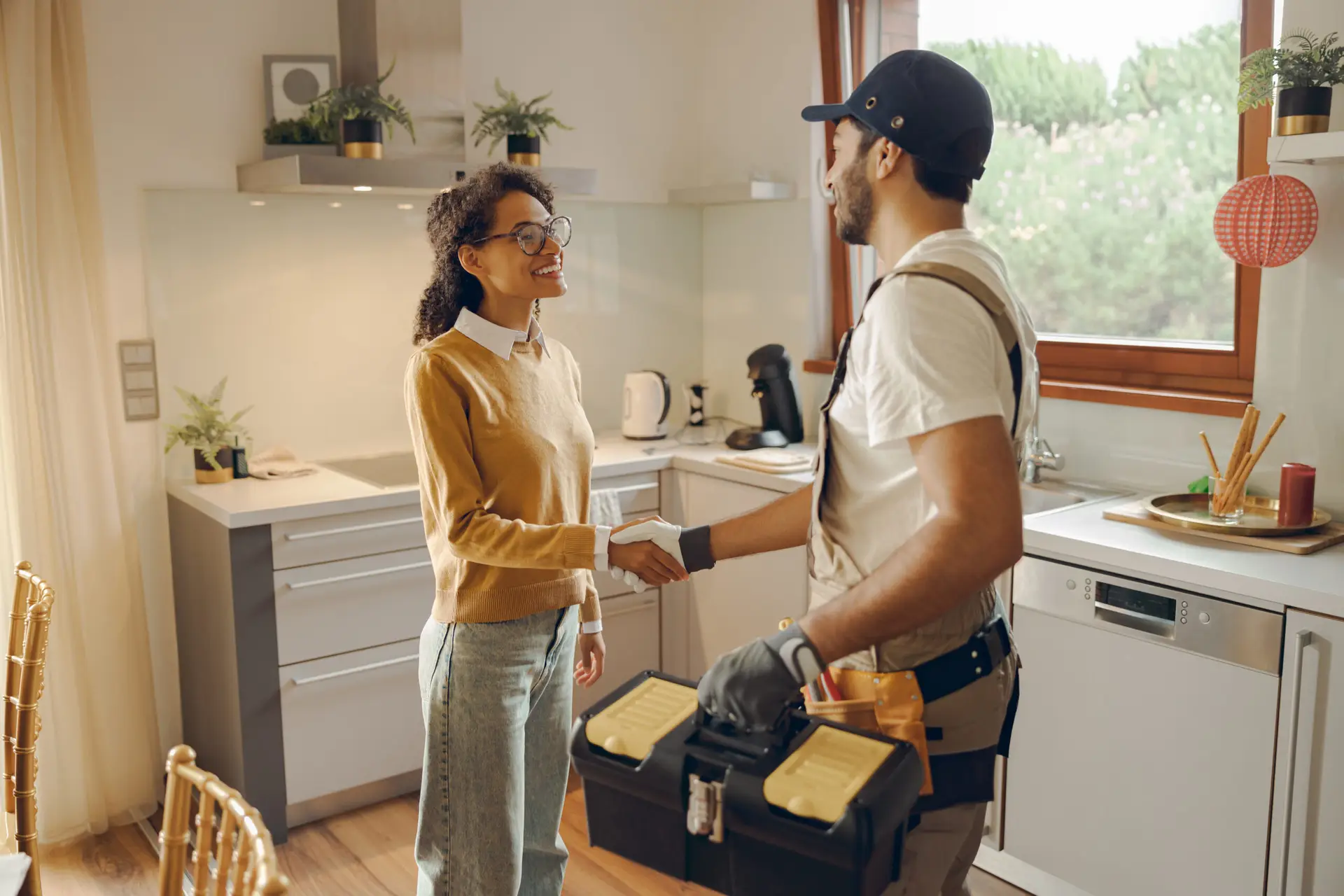 Uniformed service technician shaking hands with a homeowner at the front door
